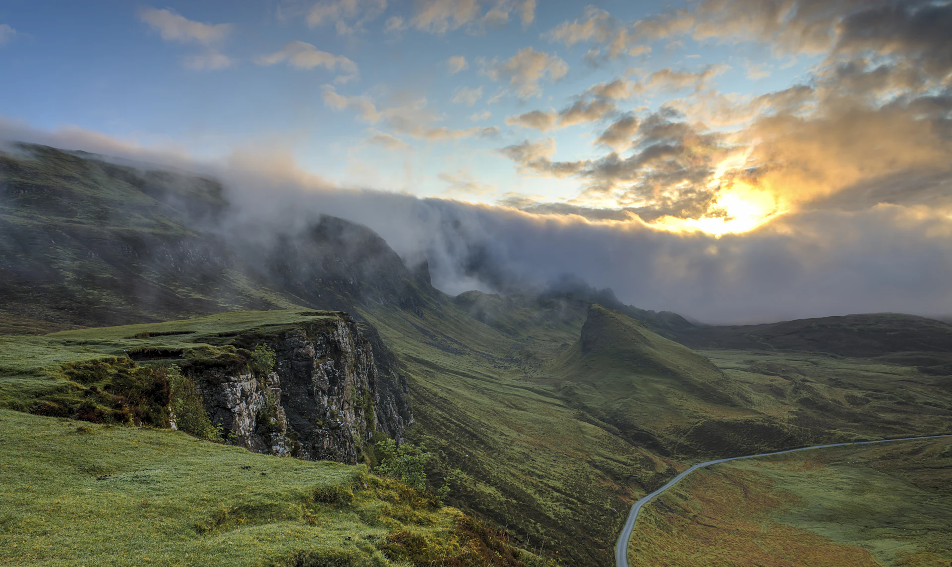 Vale montanhoso coberto por névoa densa ao amanhecer, camadas de neblina entre florestas